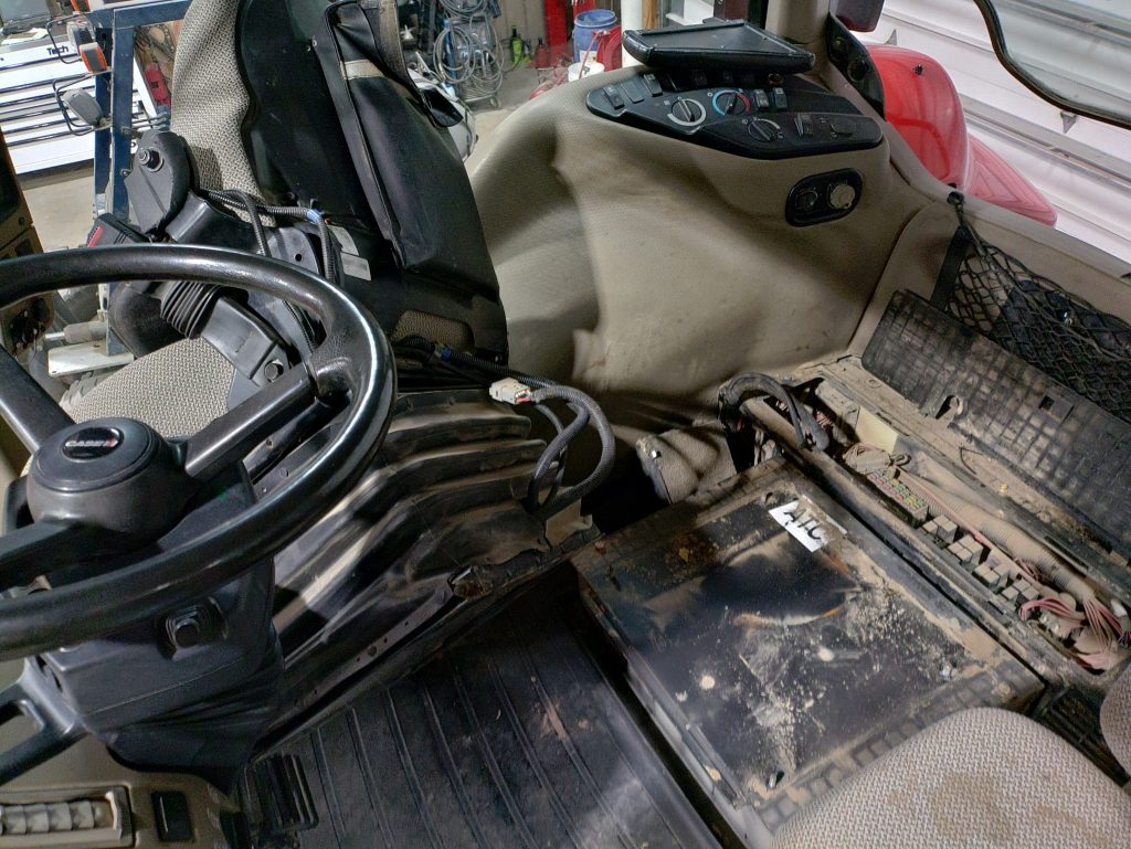 Case IH 215 Magnum cab with the seat removed to access the blower motor for replacement.
